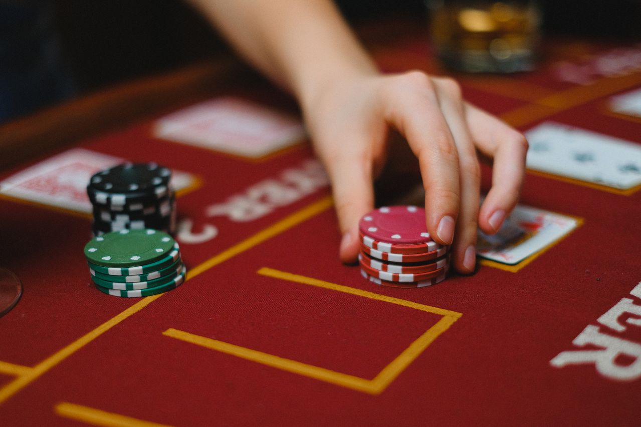 Close view of a hand resting on salon chips beside evening glassware