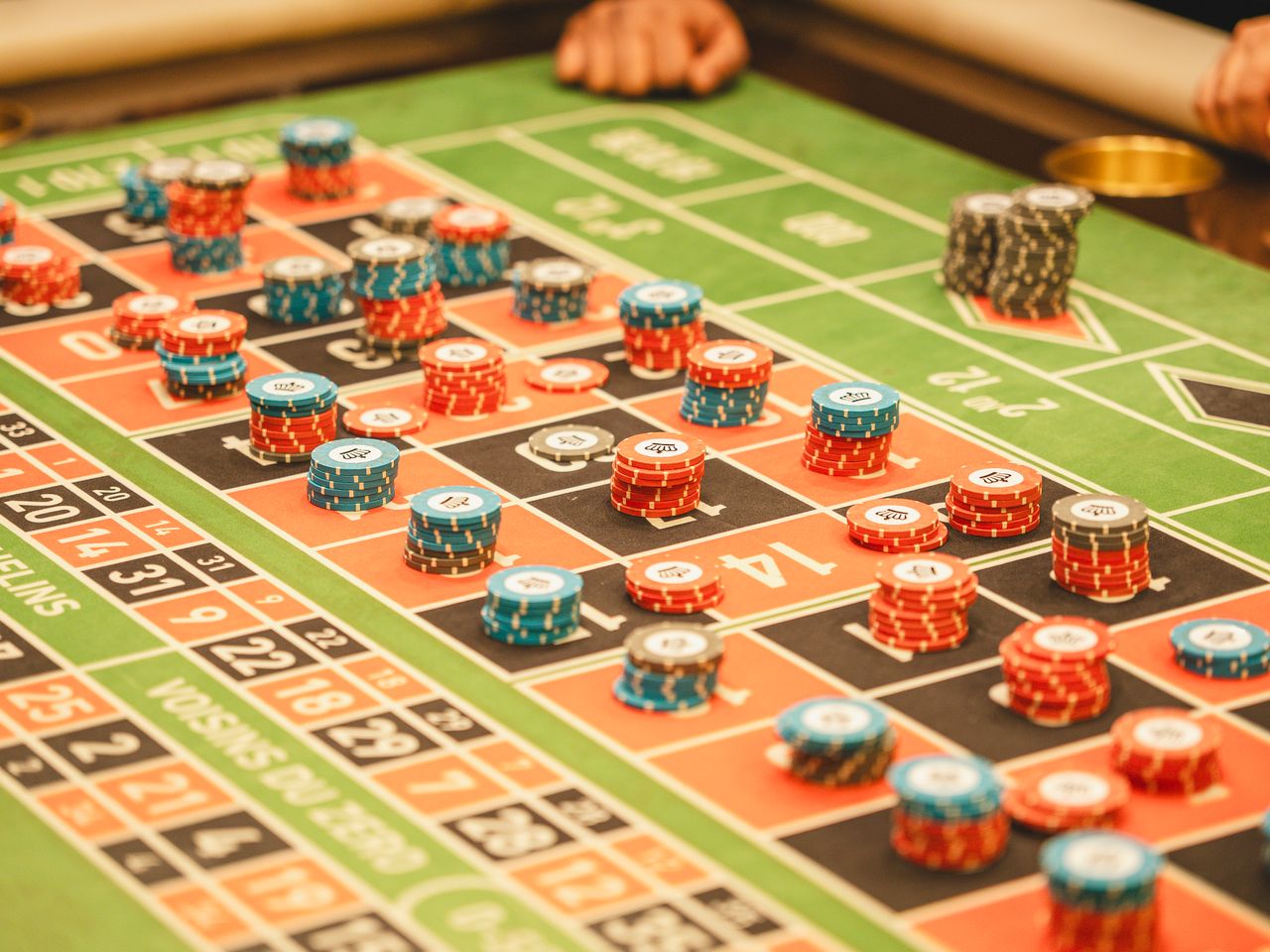 Green felt roulette layout with stacked chips during hosted play
