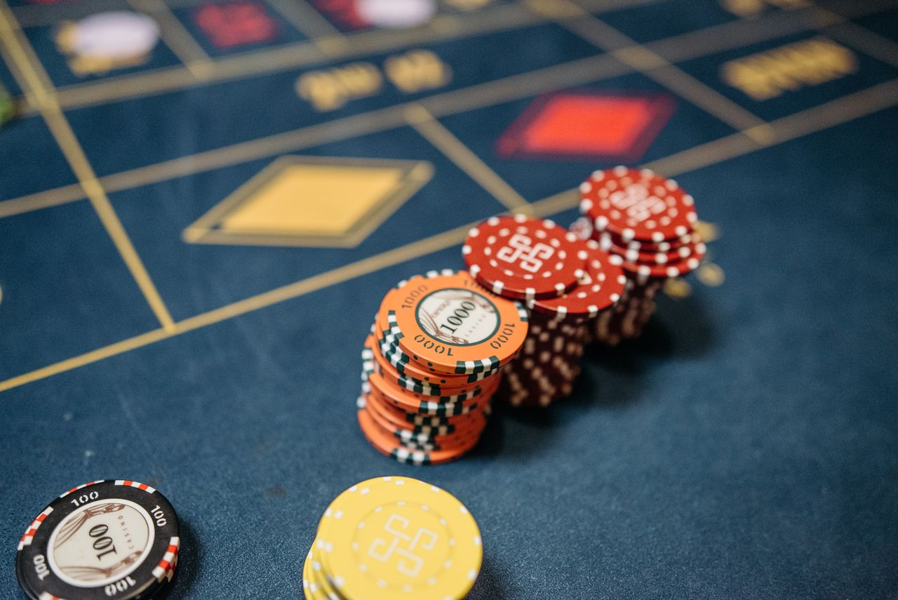 Navy felt table with orange and red chip stacks on the betting grid