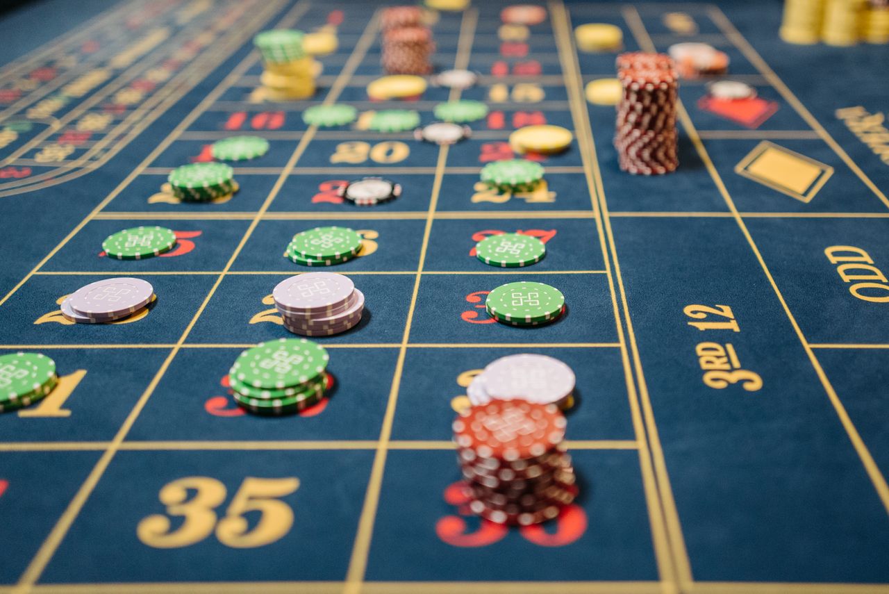 Midnight navy roulette cloth with champagne numbering and chip stacks